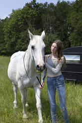 Porträt von Teeange Mädchen mit Pferd auf einer Wiese - PSTF00505