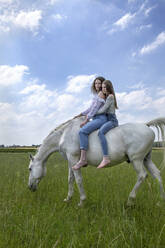 Two best friends riding together on a horse - PSTF00512