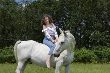 Junge Frau reitet ohne Sattel auf einem Pferd - PSTF00515