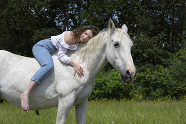 Porträt einer jungen Frau, die ohne Sattel auf einem Pferd sitzt - PSTF00516