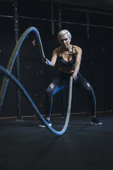 Blond sportswoman having workout with ropes - MADF01439