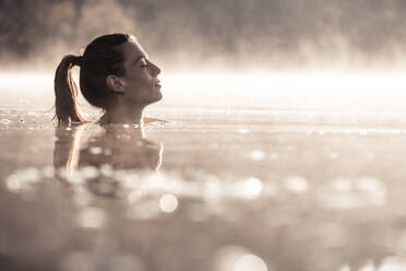 Frau badet in einem See im Morgennebel - WFF00211