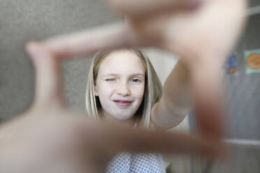 Porträt eines Mädchens, das zu Hause einen Finger berühmt macht - EYAF00753