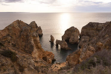 Portugal, Bezirk Faro, Lagos, Küstenklippen und Naturbogen bei Sonnenaufgang - FCF01843