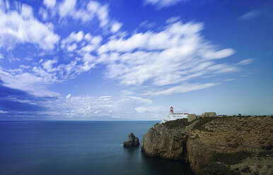 Portugal, Bezirk Faro, Lagos, Wolken über dem Leuchtturm am Rande der Küstenklippe - FCF01846