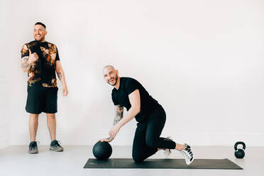 Man giving thumbs up to fitness instructor in studio - ISF23183