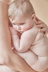 Nackte Mutter tröstet nacktes Baby, das an ihrer Brust ruht - ISF23218