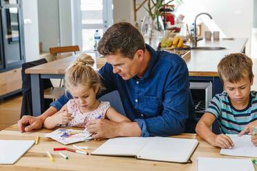 Eltern helfen Kindern bei den Hausaufgaben zu Hause - ISF23273