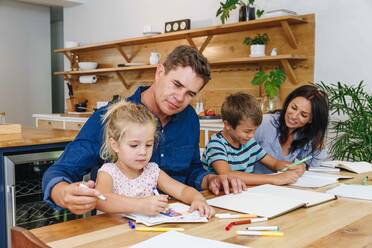 Eltern helfen Kindern bei den Hausaufgaben zu Hause - ISF23278