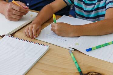 Father helping son with homework at home - ISF23340