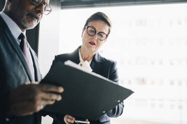 Senior professional discussing strategy with colleague at workplace - MASF15085