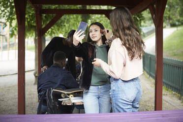 Teenager-Mädchen trägt Make-up auf eine Freundin auf, die ein Selfie macht - MASF15122