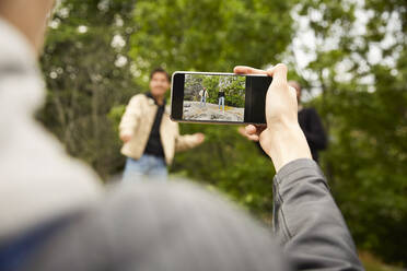 Gefangenes Bild eines Teenagers, der seine Freunde beim Tanzen im Park fotografiert - MASF15133