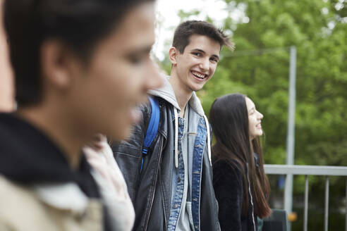 Lächelnder Teenager, der seinen Freund beim Spaziergang in der Stadt anschaut - MASF15144