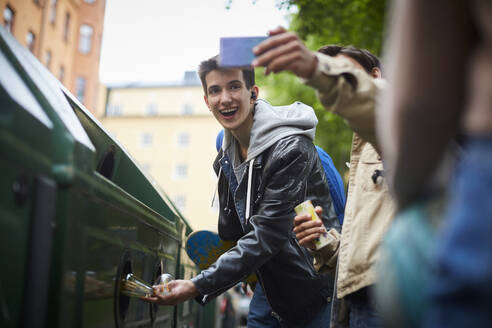 Mann macht Selfie mit Teenager-Freundin und wirft Abfall in Mülltonne an Recycling-Station - MASF15157
