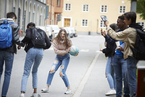 Lächelnde Männer, die spielerische Freunde auf der Straße fotografieren - MASF15162