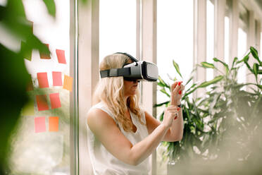 Businesswoman wearing virtual reality simulator at convention center - MASF15227