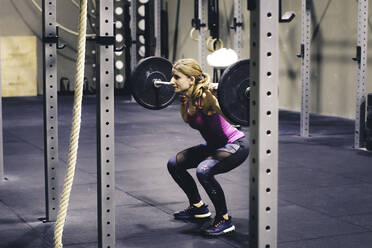 Junges Mädchen hebt Gewichte in einem Crossfit-Fitnessstudio - CAVF69926
