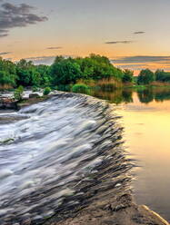 Schöner Blick auf den Damm am Fluss bei Sonnenuntergang - CAVF69927