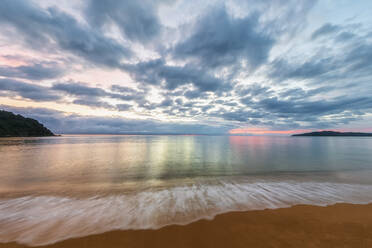 New Zealand, Long exposure of clouds over sandy coastal beach at dusk - FOF11359