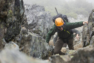 Bergsteiger beim Besteigen eines felsigen Berges. - CAVF69989