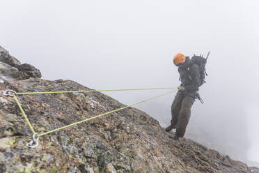 Top view of climber rappelling down mountainside. - CAVF69990