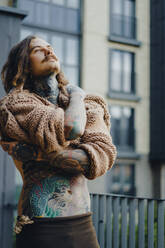 Handsome tattooed sexy man with long hair and mustache outdoors - CAVF70014