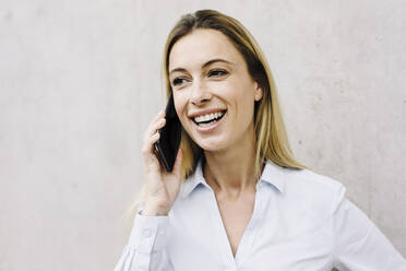 Portrait of a happy young businesswoman on the phone - JOSF03845