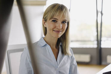 Portrait of a smiling young businesswoman in office - JOSF03857