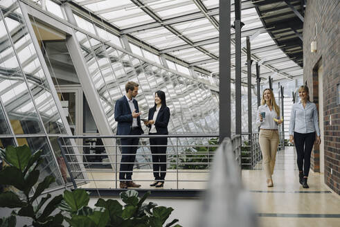 Geschäftsleute im Gespräch in einem modernen Bürogebäude - JOSF03898