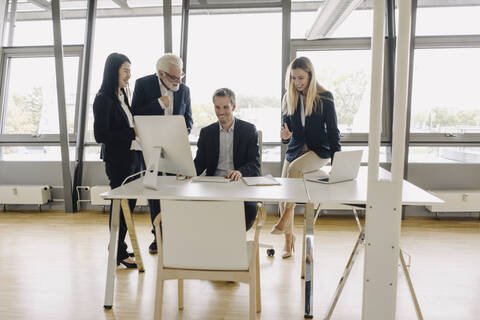 Glückliche Geschäftsleute bei einem Treffen im Büro, lizenzfreies Stockfoto