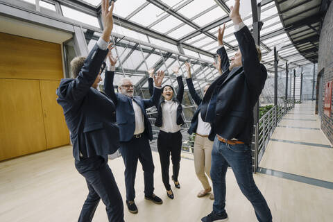 Glückliche Geschäftsleute jubeln in einem modernen Bürogebäude, lizenzfreies Stockfoto