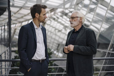 Two businessmen talking in modern office building - JOSF03964