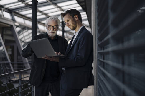 Zwei Geschäftsleute benutzen gemeinsam einen Laptop im Büro - JOSF03967