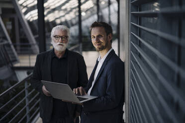 Porträt von zwei Geschäftsleuten mit Laptop im Büro - JOSF03968