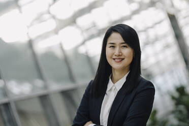 Portrait of a smiling businesswoman in a modern office building - JOSF03973