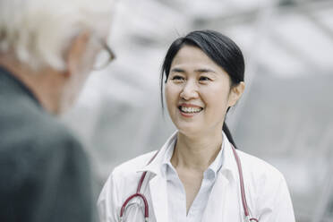 Smiling female doctor talking to senior man - JOSF03986