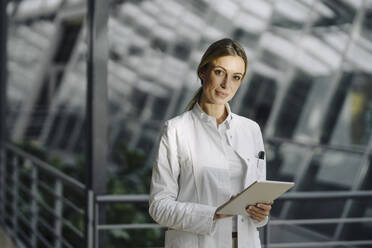 Portrait of a confident female doctor holding tablet - JOSF03998