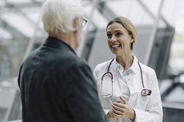 Smiling female doctor talking to senior man - JOSF04004