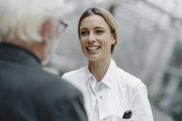 Smiling female doctor talking to senior man - JOSF04005