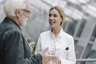 Smiling female doctor talking to senior man - JOSF04006