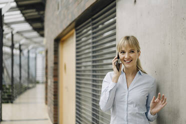 Portrait of a smiling young businesswoman on the phone - JOSF04015