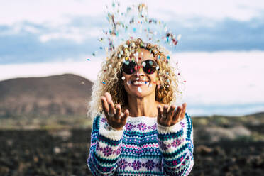 Happy blond woman throwing confetti in the air, Tenerife, Spain - SIPF02098