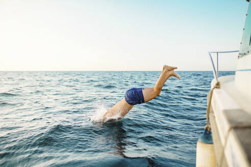 Young man jumping into the sea from a boat - MIMFF00030