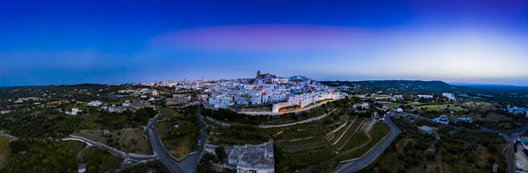 Italien, Provinz Brindisi, Ostuni, Luftbild der hügeligen Altstadt in der Abenddämmerung - AMF07600