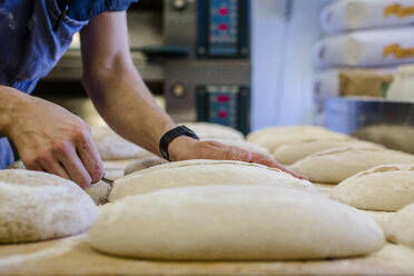 Close-up view of professional baker preparing bread dough in a kitchen - CAVF70224