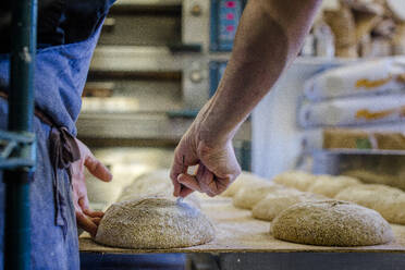 Nahaufnahme eines Bäckers, der einen gesäten Brotteig für den Ofen vorbereitet - CAVF70226