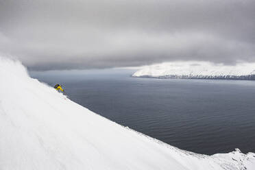 A man backcountry skiing to the ocean at in Iceland. - CAVF70230