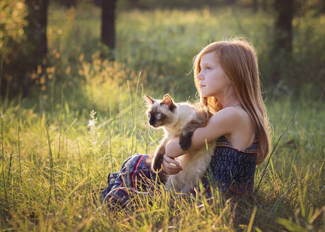 Young Girl With Kitten Outdoors in Meadow - CAVF70240