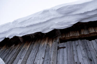 Niedriger Blickwinkel auf das schneebedeckte Dach eines Gebäudes - CAVF70266